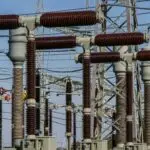 Detailed view of high voltage electrical substation with transformers and power lines.