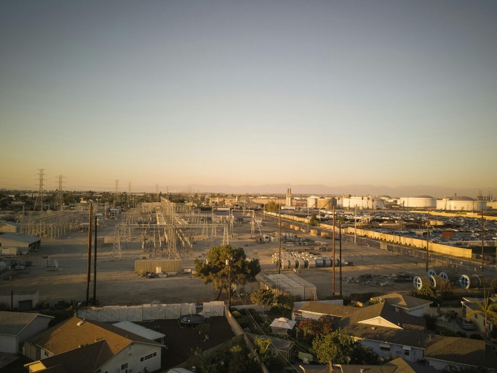 An aerial shot of an industrial power plant and surrounding areas during sunset, showcasing energy infrastructure.